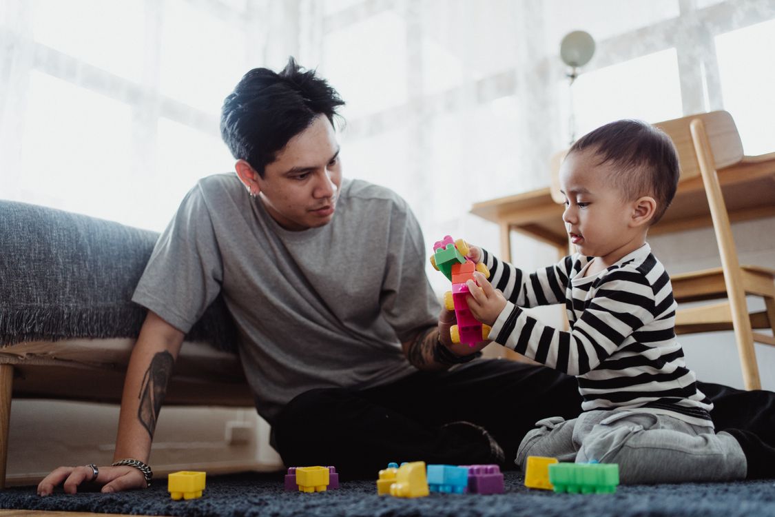Padre e hija jugando juntos en el suelo de casa