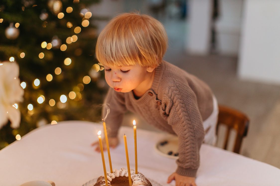 Un niño sopla las velas de una tarta de cumpleaños